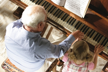 Grandpa and granddaughter playing the piano - bird´s-eye view
